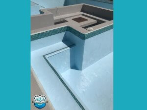 Newly coated swimming pool featuring smooth blue epoxy finish on walls and floor - completed restoration project in Belize