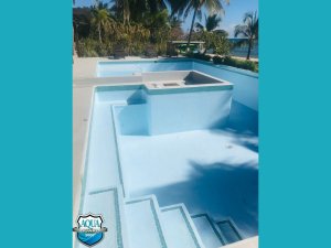 Newly coated swimming pool featuring smooth blue epoxy finish on walls and floor - completed restoration project in Belize